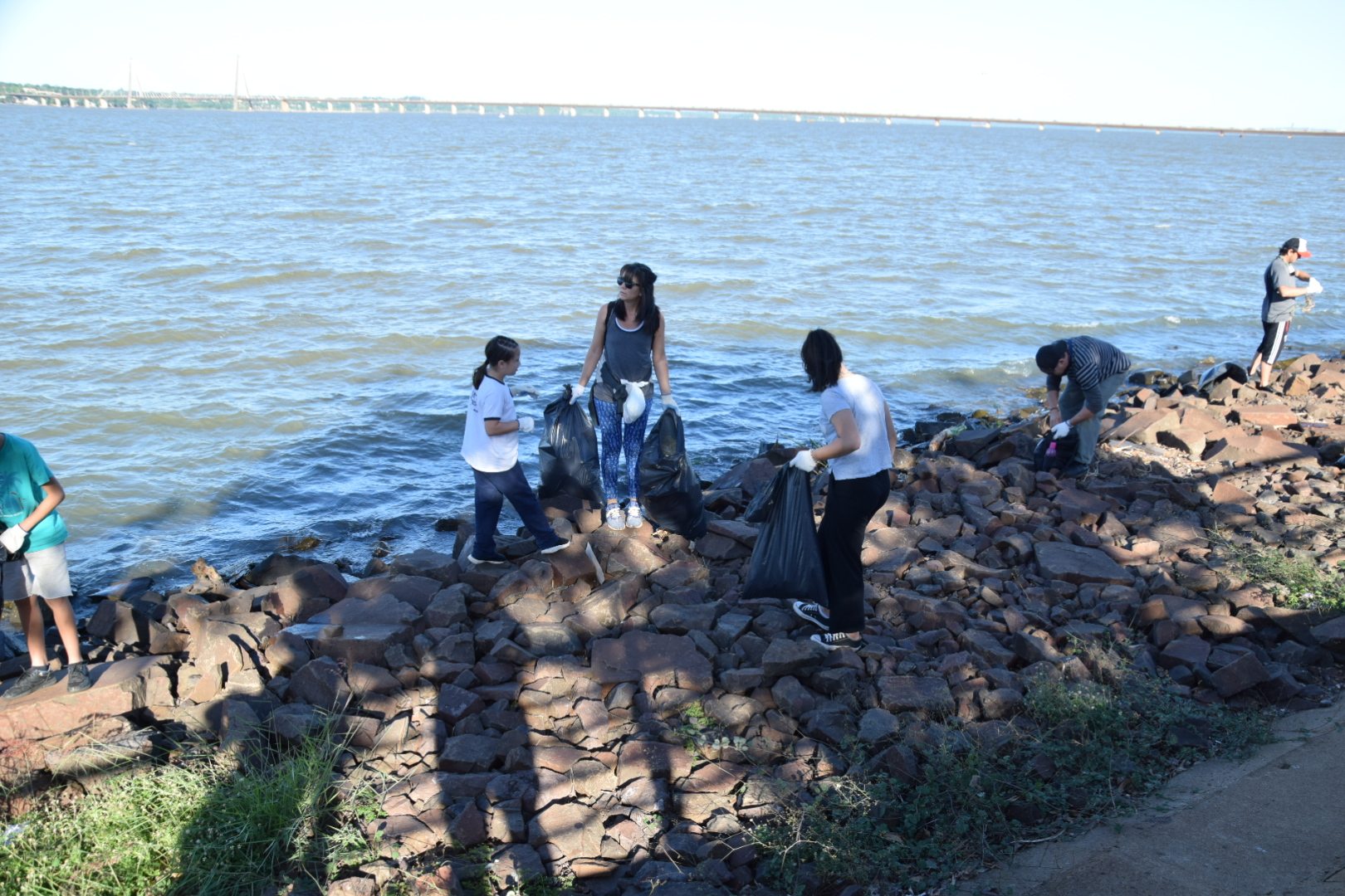 Personas realizando una acción de limpieza en la costanera